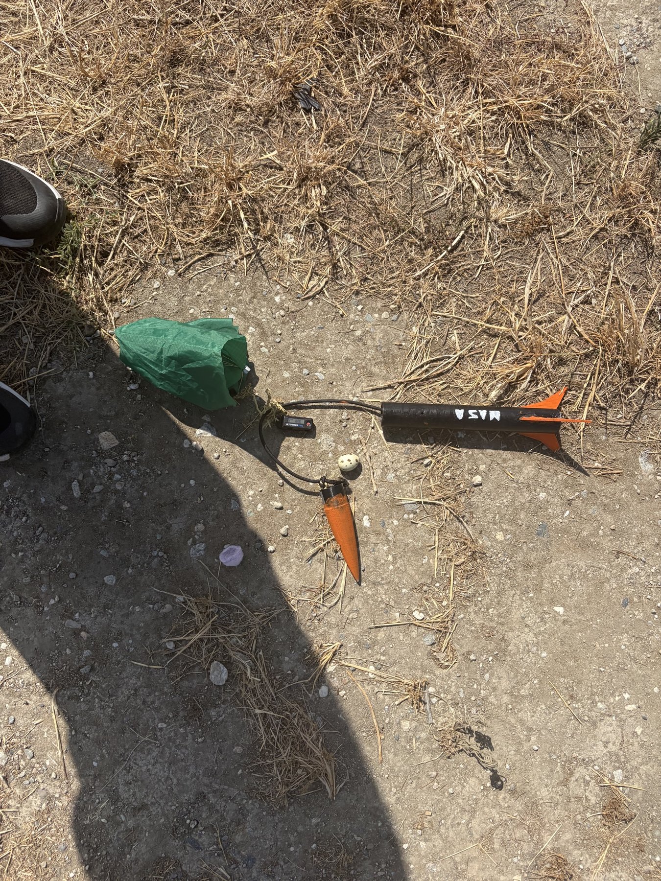 Recovered rocket, nose cone, parachute and egg on the ground